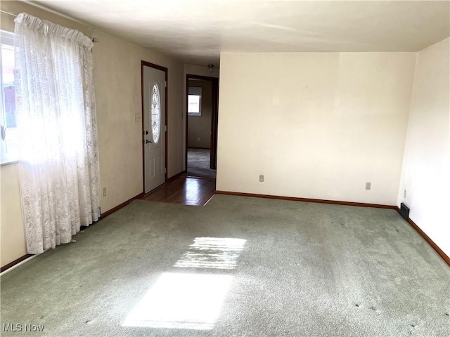 foyer with baseboards and carpet