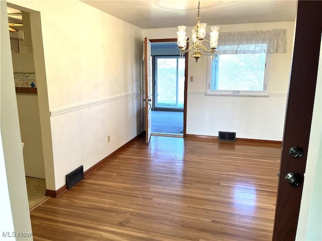 interior space with wood finished floors, visible vents, and a chandelier