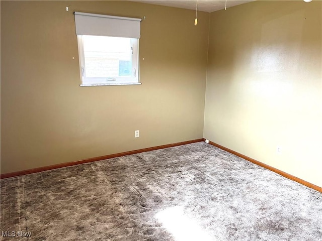 carpeted empty room with baseboards