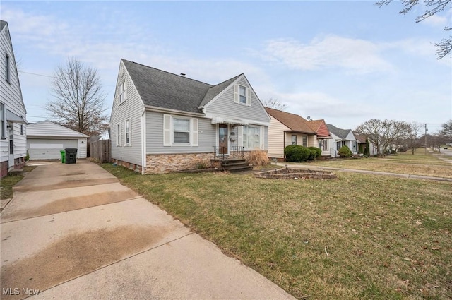 view of front of property with a garage, an outdoor structure, a front yard, and a shingled roof