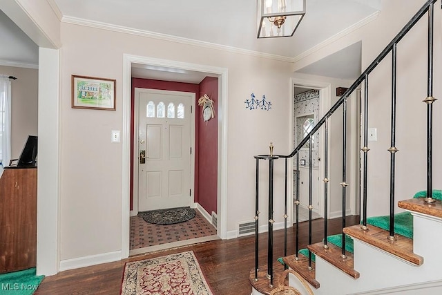 foyer featuring wood finished floors, baseboards, visible vents, stairs, and crown molding