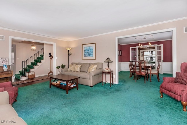 carpeted living room featuring a wainscoted wall, crown molding, stairway, and visible vents