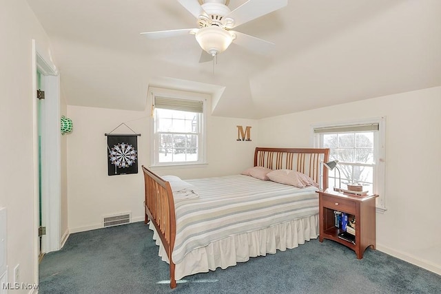 carpeted bedroom featuring visible vents, multiple windows, and vaulted ceiling