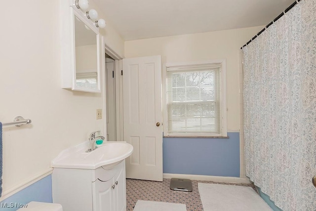 bathroom with vanity, a shower with shower curtain, and baseboards