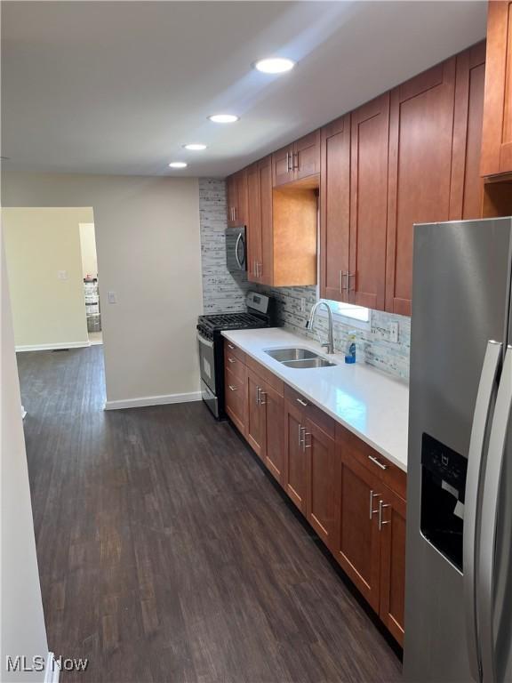 366 Tenney Ave, Campbell, OH 44405 - kitchen featuring a sink, stainless steel appliances, backsplash, and dark wood-style flooring