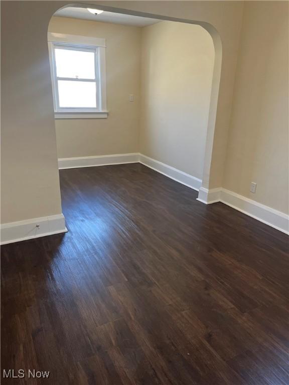 366 Tenney Ave, Campbell, OH 44405 - empty room with arched walkways, dark wood finished floors, and baseboards