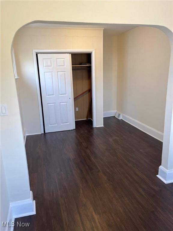 366 Tenney Ave, Campbell, OH 44405 - unfurnished bedroom with arched walkways, dark wood-style floors, a closet, and baseboards