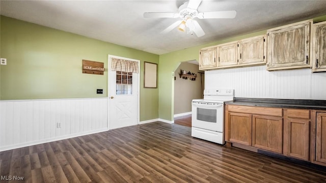 kitchen with dark wood finished floors, electric range, ceiling fan, and a wainscoted wall