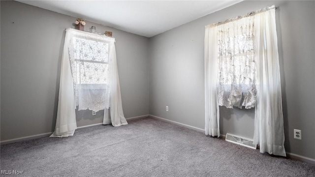 carpeted empty room featuring visible vents and baseboards