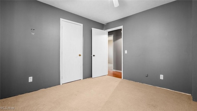 unfurnished bedroom with a ceiling fan, a closet, and carpet floors