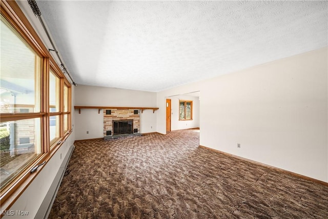 unfurnished living room featuring a healthy amount of sunlight, a fireplace, a textured ceiling, and carpet floors