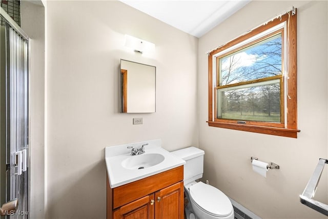 bathroom featuring a shower with shower door, toilet, and vanity