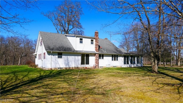 back of house with a yard, roof with shingles, and a chimney