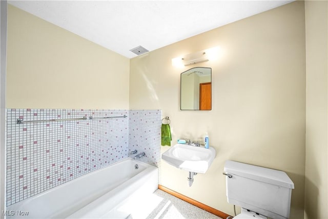 full bathroom with visible vents, baseboards, a sink, a garden tub, and toilet