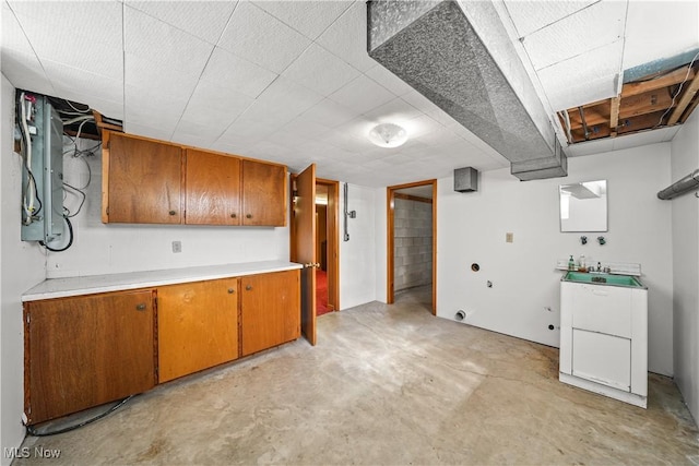 kitchen featuring brown cabinets, concrete flooring, and light countertops