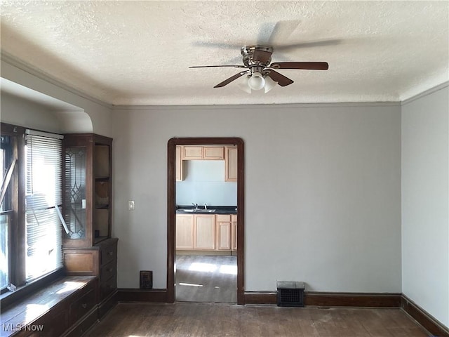 3370 E 145th St, Cleveland, OH 44120 - empty room with a ceiling fan, a sink, a textured ceiling, dark wood finished floors, and baseboards