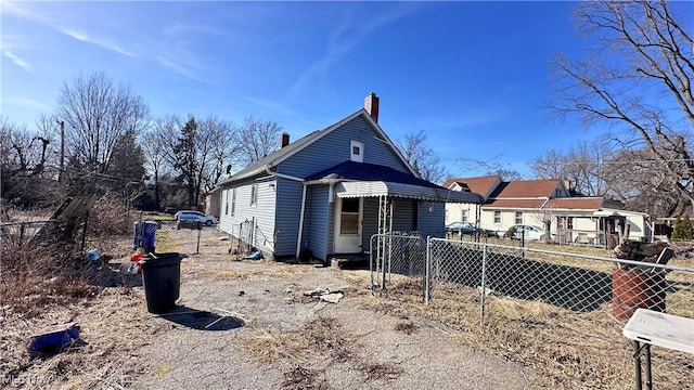 view of front of home with a chimney and fence