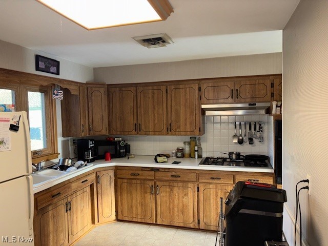 1317 Hartzell, Niles, OH 44446 - kitchen featuring visible vents, under cabinet range hood, light countertops, freestanding refrigerator, and gas cooktop