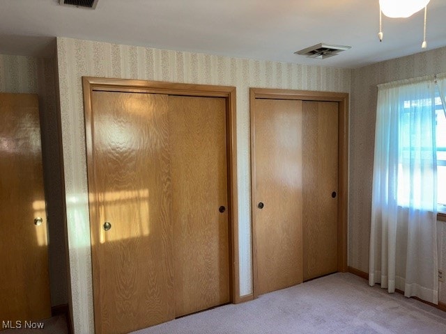 1317 Hartzell, Niles, OH 44446 - unfurnished bedroom featuring visible vents, two closets, wallpapered walls, and carpet floors