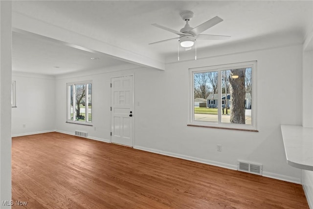 entryway featuring wood finished floors, baseboards, and visible vents