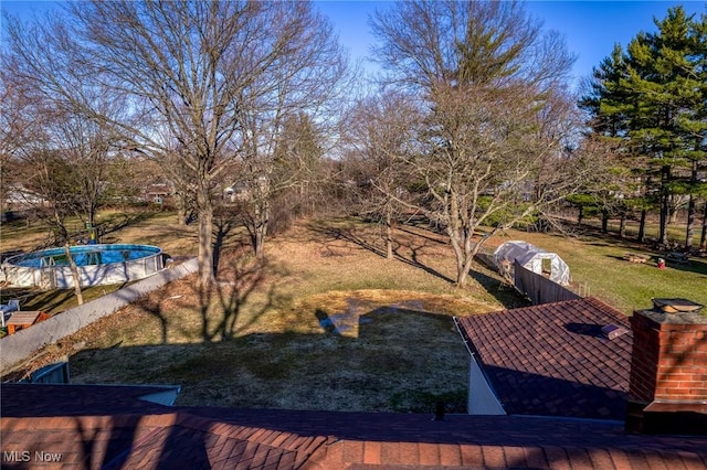 view of yard with a pool and fence