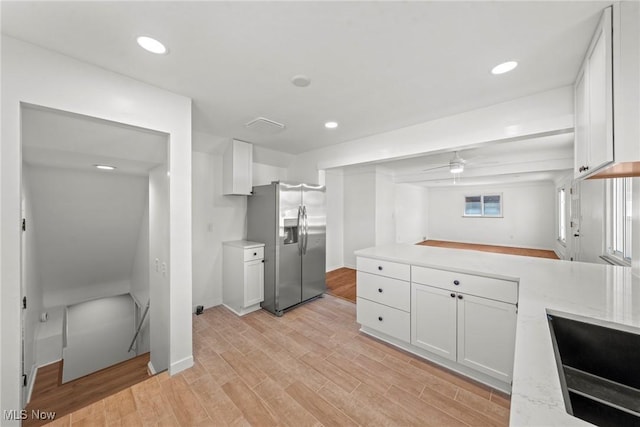 kitchen featuring light wood-type flooring, recessed lighting, white cabinetry, a ceiling fan, and stainless steel refrigerator with ice dispenser