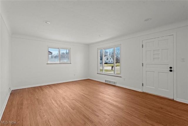 empty room featuring visible vents, baseboards, and light wood-style flooring