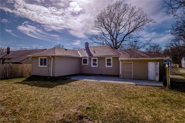 rear view of property featuring a chimney, a patio area, fence, and a lawn