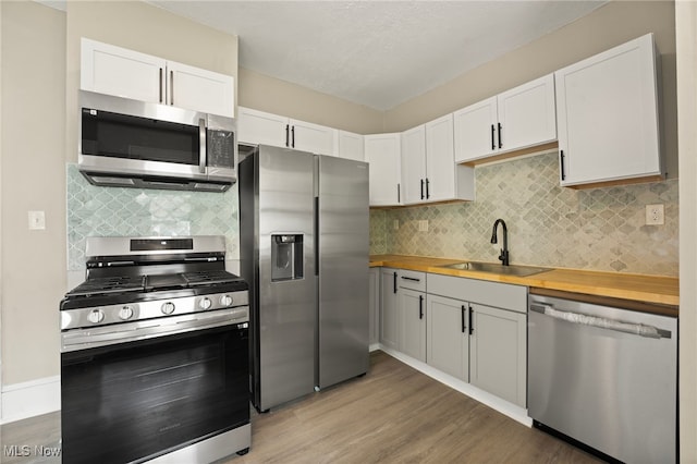 1344 E 112th St, Cleveland, OH 44106 - kitchen featuring a sink, white cabinetry, wooden counters, and stainless steel appliances
