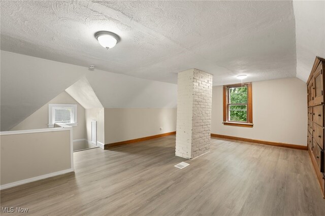 1344 E 112th St, Cleveland, OH 44106 - bonus room featuring light wood-style flooring, a textured ceiling, lofted ceiling, and baseboards