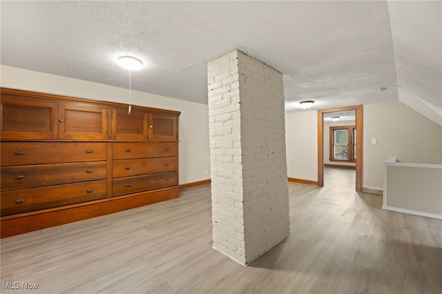 1344 E 112th St, Cleveland, OH 44106 - bonus room with baseboards, light wood-style floors, vaulted ceiling, and a textured ceiling