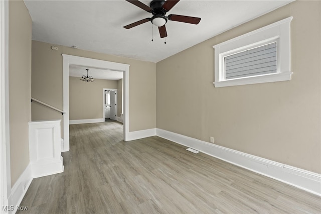 1344 E 112th St, Cleveland, OH 44106 - spare room with visible vents, baseboards, wood finished floors, and ceiling fan with notable chandelier