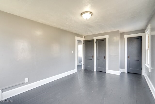 323 Belden Ave NE, Canton, OH 44704 - unfurnished bedroom featuring baseboards and dark wood-style flooring