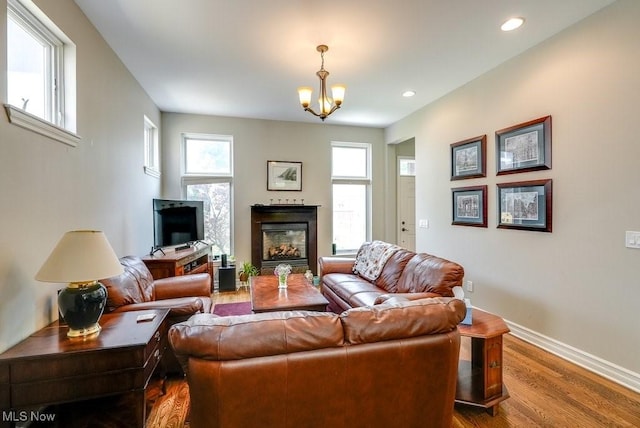 1581 E 118th St, Cleveland, OH 44106 - living area featuring a glass covered fireplace, wood finished floors, recessed lighting, an inviting chandelier, and baseboards