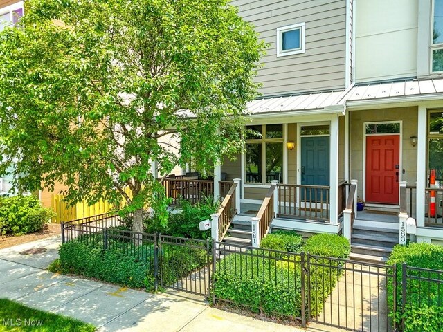 1581 E 118th St, Cleveland, OH 44106 - view of exterior entry with a standing seam roof, a porch, fence, and metal roof