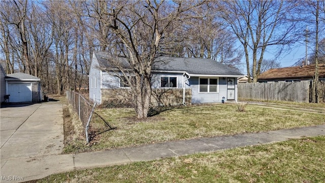 view of front of property featuring a front yard, concrete driveway, fence, and an outdoor structure
