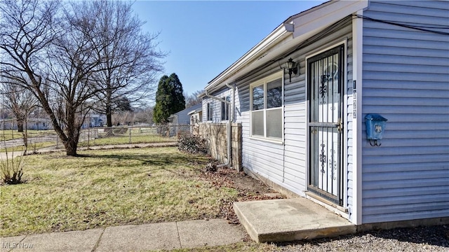 view of property exterior featuring fence and a lawn