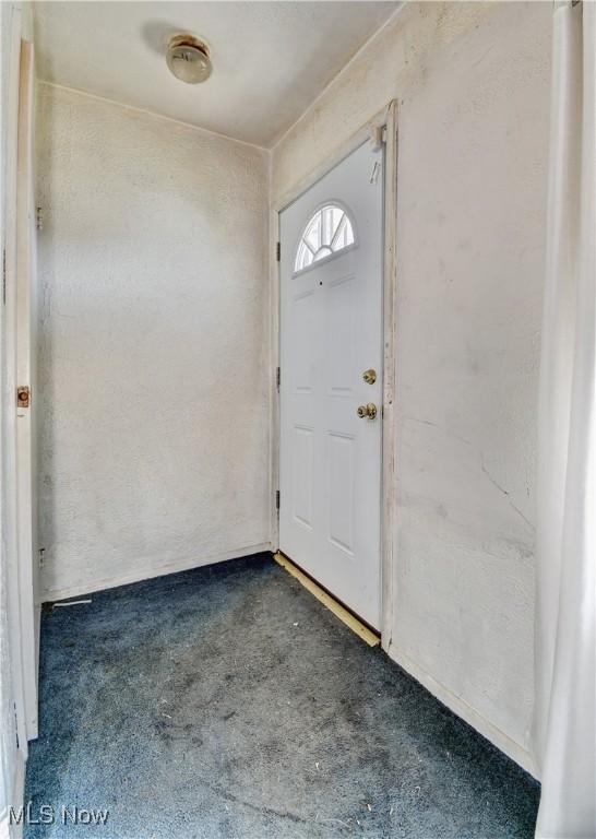 foyer entrance with dark colored carpet