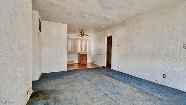 empty room with a ceiling fan and a textured wall