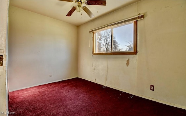 spare room featuring a ceiling fan and dark colored carpet