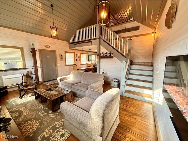 16223 Wooly Bear Ln, Kimbolton, OH 43749 - living room featuring wood finished floors, wood walls, stairway, vaulted ceiling, and cooling unit