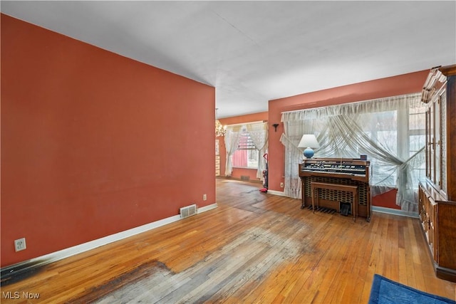 living area with visible vents, baseboards, and hardwood / wood-style floors