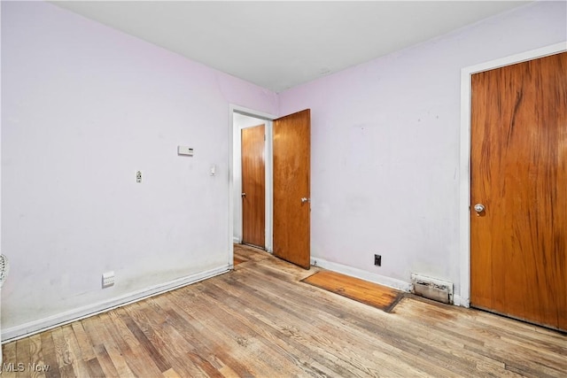 unfurnished room with baseboards and wood finished floors