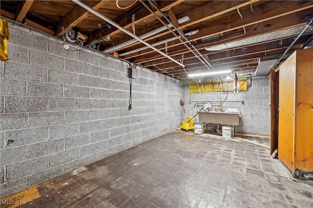 unfinished below grade area with tile patterned floors and a sink