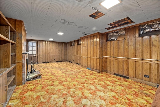 basement featuring wooden walls and carpet floors