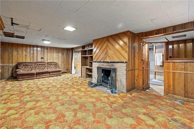 unfurnished living room featuring wooden walls, a fireplace, and carpet