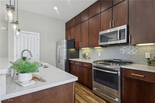 1228 W 74th St, Cleveland, OH 44102 - kitchen with tasteful backsplash, appliances with stainless steel finishes, wood finished floors, and light countertops