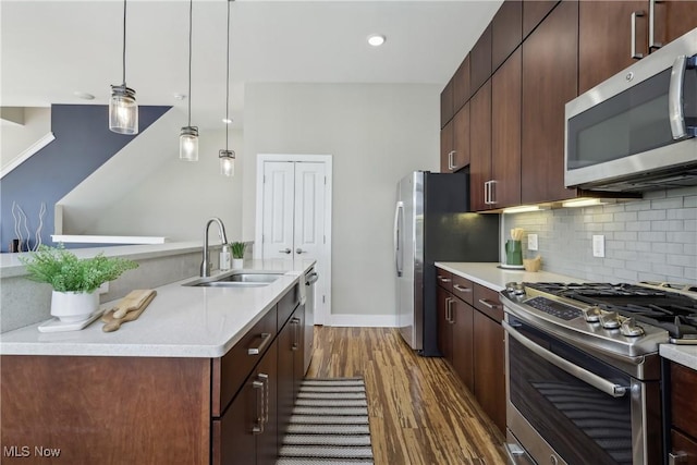1228 W 74th St, Cleveland, OH 44102 - kitchen with tasteful backsplash, dark wood-type flooring, light countertops, appliances with stainless steel finishes, and a sink
