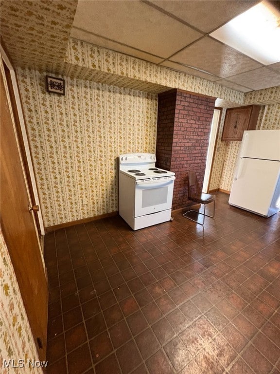 kitchen featuring a drop ceiling, baseboards, white appliances, and wallpapered walls