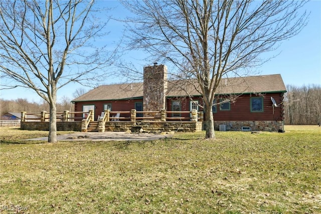 1525 Old Kyle Rd, Dorset, OH 44032 - back of house featuring central AC unit, a chimney, a deck, log exterior, and a lawn